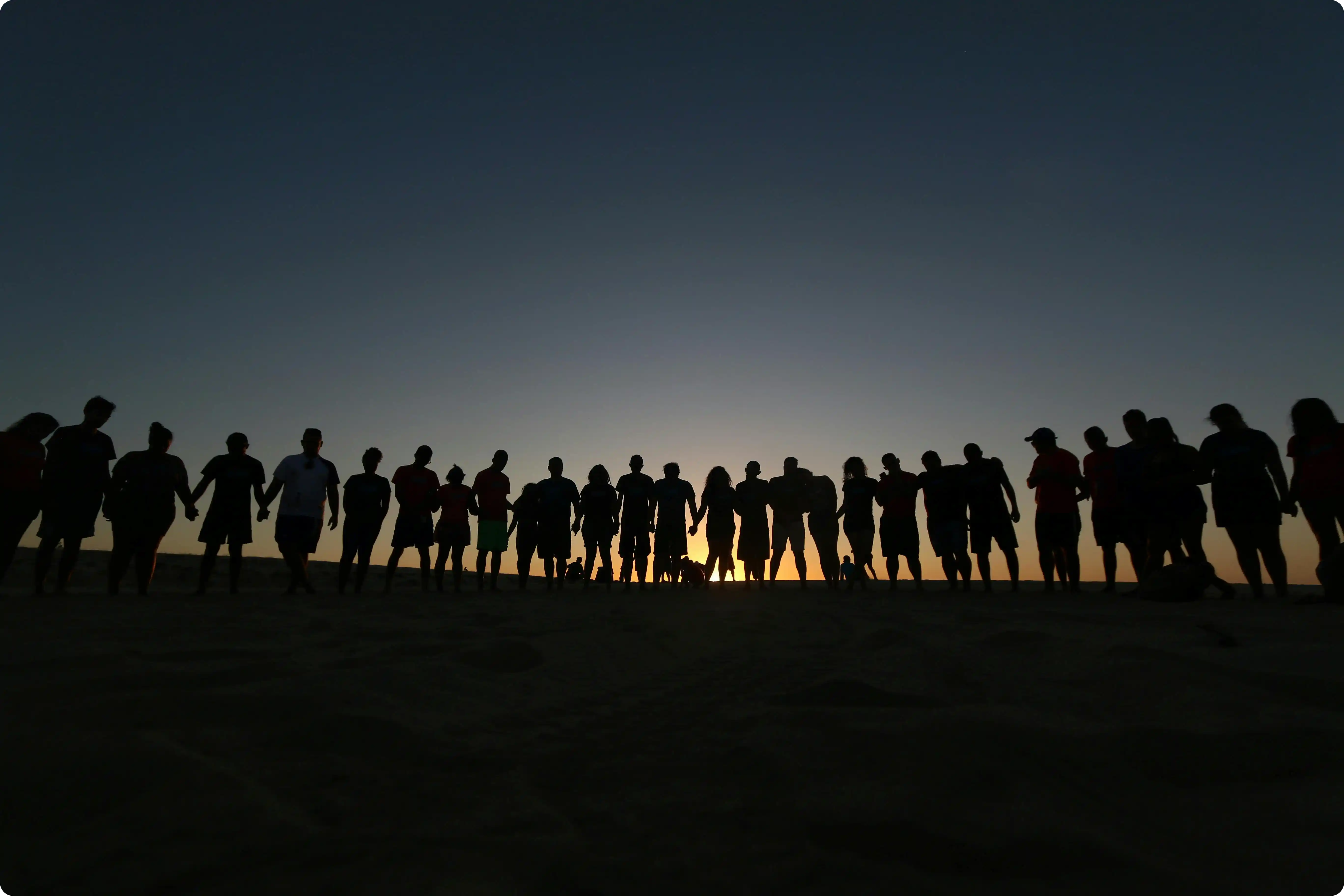people standing in a line during sunset